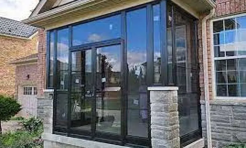 Glass porch enclosure on a brick home